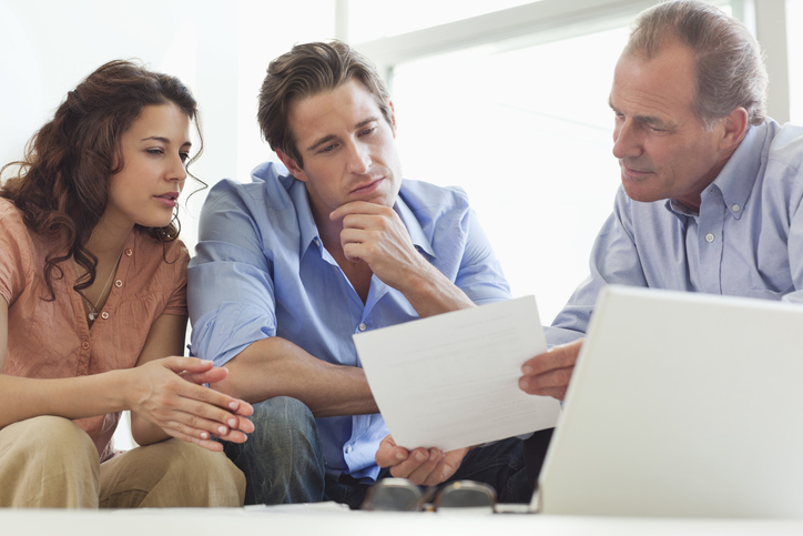 A financial advisor helping a couple estimate how much money they will need to pay for travel in retirement.